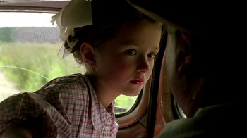 Movie still from “Burnt by the Sun” (1994), directed by Nikita Mikhalkov – A little girl sitting in a car looking out the window; Close Up shot, Over the shoulder angle