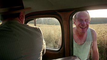 Movie still from “Burnt by the Sun” (1994), directed by Nikita Mikhalkov – Two men in a car looking out a window; Medium shot, Over the shoulder angle