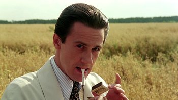 Movie still from “Burnt by the Sun” (1994), directed by Nikita Mikhalkov – A man in a white suit is holding a chocolate bar; Close Up shot, Low angle