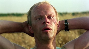 Movie still from “Burnt by the Sun” (1994), directed by Nikita Mikhalkov – A person with his hands behind his head; Close Up shot, Low angle