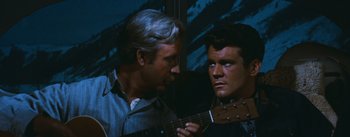 Movie still from “Bus Stop” (1956), directed by Joshua Logan – A man holding a guitar next to another man; Close Up shot, Over the shoulder angle