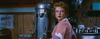 Movie still from “Bus Stop” (1956), directed by Joshua Logan – A woman standing in front of a coffee maker; Close Up shot, Low angle