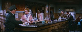 Movie still from “Bus Stop” (1956), directed by Joshua Logan – A woman sitting at the bar of a restaurant; Medium shot, Over the shoulder angle