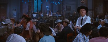 Movie still from “Bus Stop” (1956), directed by Joshua Logan – A group of men sitting around a table; Wide shot, High angle