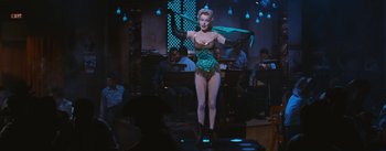 Movie still from “Bus Stop” (1956), directed by Joshua Logan – A woman in a green and black costume on stage; Wide shot, Low angle