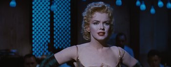 Movie still from “Bus Stop” (1956), directed by Joshua Logan – A woman with blonde curly hair wearing a white dress; Close Up shot, Over the shoulder angle