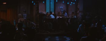 Movie still from “Bus Stop” (1956), directed by Joshua Logan – A group of men sitting around a bar playing instruments; Wide shot, High angle