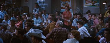 Movie still from “Bus Stop” (1956), directed by Joshua Logan – A group of people sitting around a room; Wide shot, Over the shoulder angle