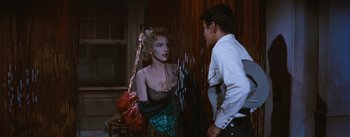 Movie still from “Bus Stop” (1956), directed by Joshua Logan – A man and a woman standing next to each other in a room; Medium shot, Over the shoulder angle