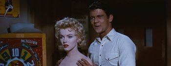 Movie still from “Bus Stop” (1956), directed by Joshua Logan – A man standing next to a woman in a white shirt; Medium shot, Over the shoulder angle