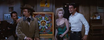 Movie still from “Bus Stop” (1956), directed by Joshua Logan – A man and a woman standing in front of a pinball machine; Medium shot, Over the shoulder angle