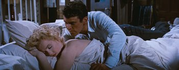 Movie still from “Bus Stop” (1956), directed by Joshua Logan – A man leaning over a woman lying on a bed; Medium shot, High angle