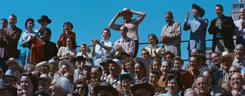 Movie still from “Bus Stop” (1956), directed by Joshua Logan – A group of people sitting in a stadium watching a baseball game; Wide shot, High angle