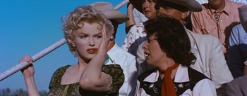 Movie still from “Bus Stop” (1956), directed by Joshua Logan – A woman in a cowboy hat is holding her hand up to her face; Close Up shot, Over the shoulder angle