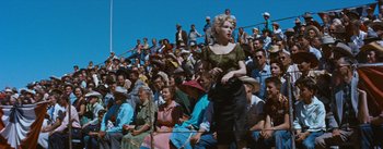 Movie still from “Bus Stop” (1956), directed by Joshua Logan – A crowd of people sitting on bleachers watching an event; Wide shot, High angle