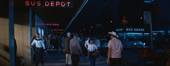 Movie still from “Bus Stop” (1956), directed by Joshua Logan – A group of people walking down a street at night; Wide shot, Low angle