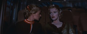 Movie still from “Bus Stop” (1956), directed by Joshua Logan – Two women sitting next to each other on a bus; Close Up shot, Over the shoulder angle