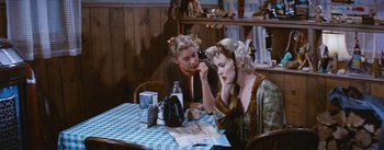 Movie still from “Bus Stop” (1956), directed by Joshua Logan – Two women are sitting at a table with a map; Medium shot, Over the shoulder angle