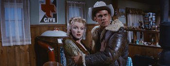 Movie still from “Bus Stop” (1956), directed by Joshua Logan – A man and a woman standing next to each other in a room; Medium shot, Low angle