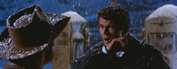 Movie still from “Bus Stop” (1956), directed by Joshua Logan – A man in a black jacket standing in the rain with an umbrella; Close Up shot, Low angle
