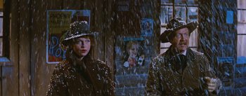 Movie still from “Bus Stop” (1956), directed by Joshua Logan – Two women in rain coats and hats standing next to each other in the rain; Medium shot, Low angle