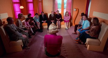 A group of people sitting in a circle with a woman