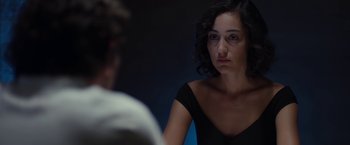 A woman in a black dress looking at a man in a white shirt