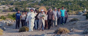 A group of people walking down a dirt road