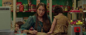 Movie still from “By the Sea” (2015), directed by Angelina Jolie – A woman sitting at a table writing on a piece of paper; Close Up shot, Over the shoulder angle