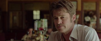 Movie still from “By the Sea” (2015), directed by Angelina Jolie – A person sitting at a table; Close Up shot, Over the shoulder angle