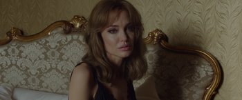 Movie still from “By the Sea” (2015), directed by Angelina Jolie – A woman sitting in a chair looking at the camera; Close Up shot, Over the shoulder angle