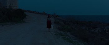Movie still from “By the Sea” (2015), directed by Angelina Jolie – A woman walking down a dirt road at night; Extreme Wide shot, High angle