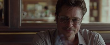 Movie still from “By the Sea” (2015), directed by Angelina Jolie – A person wearing glasses; Close Up shot, Over the shoulder angle