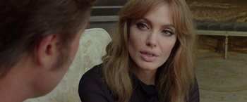 Movie still from “By the Sea” (2015), directed by Angelina Jolie – A woman sitting in front of a man with long brown hair; Close Up shot, Over the shoulder angle