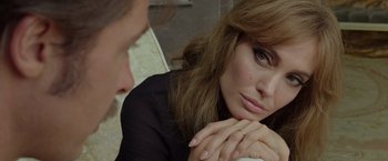 Movie still from “By the Sea” (2015), directed by Angelina Jolie – A person sitting with their hand on her chin; Close Up shot, Over the shoulder angle