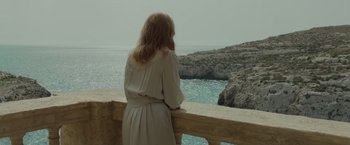 Movie still from “By the Sea” (2015), directed by Angelina Jolie – A woman standing on a balcony looking out at the ocean; Medium shot, High angle