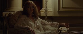 Movie still from “By the Sea” (2015), directed by Angelina Jolie – A woman sitting in a chair in a white robe; Medium shot, Over the shoulder angle
