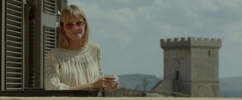 Movie still from “By the Sea” (2015), directed by Angelina Jolie – A woman holding a cup of coffee in her hands; Medium shot, Low angle