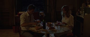 Movie still from “By the Sea” (2015), directed by Angelina Jolie – A man and a woman sitting at a dinner table; Medium shot, High angle