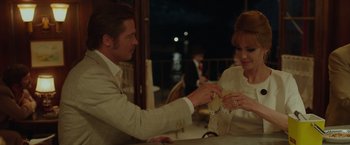 Movie still from “By the Sea” (2015), directed by Angelina Jolie – A man and a woman sitting at a dinner table; Medium shot, Over the shoulder angle