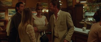 Movie still from “By the Sea” (2015), directed by Angelina Jolie – A man and a woman shaking hands in front of a woman; Medium shot, Over the shoulder angle