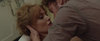 Movie still from “By the Sea” (2015), directed by Angelina Jolie – A man and a woman are kissing in a room; Close Up shot, Over the shoulder angle