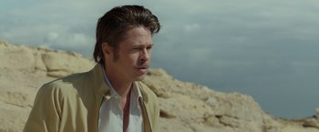 Movie still from “By the Sea” (2015), directed by Angelina Jolie – A person wearing a jacket near a cliff; Close Up shot, Over the shoulder angle