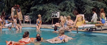 Movie still from “Bye Bye Birdie” (1963), directed by George Sidney – A group of people in a pool watching a television; Wide shot, High angle