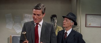 Movie still from “Bye Bye Birdie” (1963), directed by George Sidney – A man in a suit and tie next to an older man in a suit and tie; Medium shot, Over the shoulder angle
