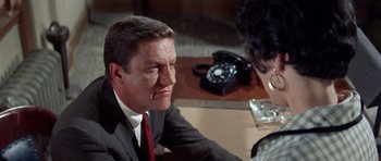 Movie still from “Bye Bye Birdie” (1963), directed by George Sidney – A man in a suit and red tie sitting at a table; Close Up shot, High angle