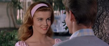 Movie still from “Bye Bye Birdie” (1963), directed by George Sidney – A young woman wearing a pink headband looks at a young man; Close Up shot, Over the shoulder angle