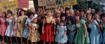 Movie still from “Bye Bye Birdie” (1963), directed by George Sidney – A group of people standing next to each other on a street; Medium shot, High angle