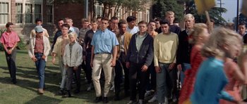 Movie still from “Bye Bye Birdie” (1963), directed by George Sidney – A group of young men standing next to each other on the grass; Wide shot, High angle