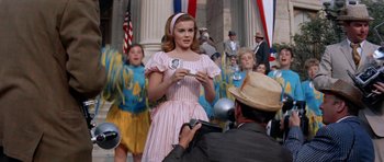 Movie still from “Bye Bye Birdie” (1963), directed by George Sidney – A woman in a striped dress holding a spoon; Medium shot, Low angle